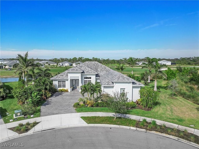 view of front of house with a front lawn, a water view, and driveway