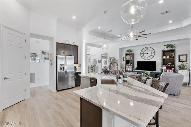 kitchen featuring light wood-type flooring, visible vents, a large island, a ceiling fan, and stainless steel appliances