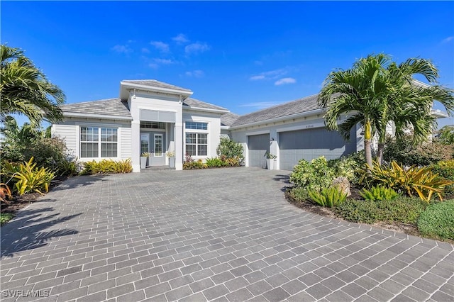 prairie-style home with decorative driveway, a garage, and a tile roof