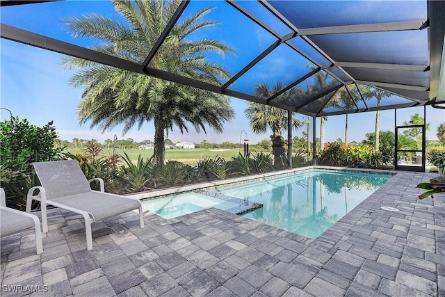 view of pool featuring a patio area, a pool with connected hot tub, and a lanai