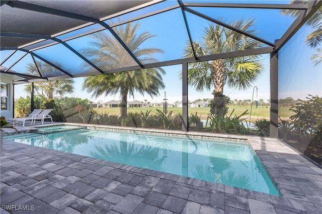 view of pool with glass enclosure, a patio, and a pool with connected hot tub