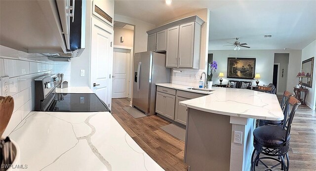 411 SW 19th Ter, Cape Coral, FL 33991 - kitchen with stove, a peninsula, stainless steel fridge with ice dispenser, and gray cabinets