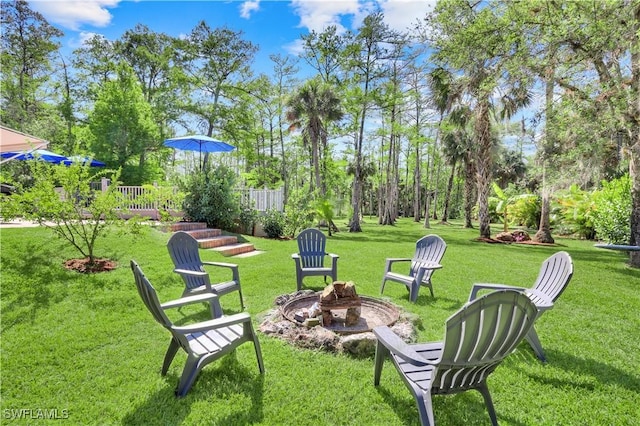 1420 14th Ave NE, Naples, FL 34120 - view of green lawn with an outdoor fire pit and view of scattered trees