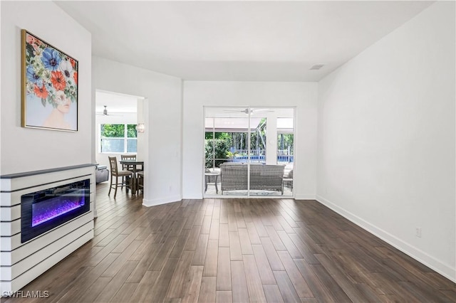 1420 14th Ave NE, Naples, FL 34120 - unfurnished living room featuring a ceiling fan, dark wood-style floors, baseboards, and a glass covered fireplace