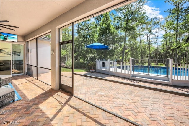 1420 14th Ave NE, Naples, FL 34120 - unfurnished sunroom featuring ceiling fan and view of wooded area