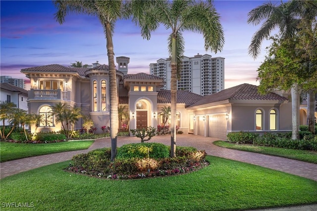 23771 Tuscany Way, Bonita Springs, FL 34134 - mediterranean / spanish-style home featuring a garage, curved driveway, stucco siding, and a yard