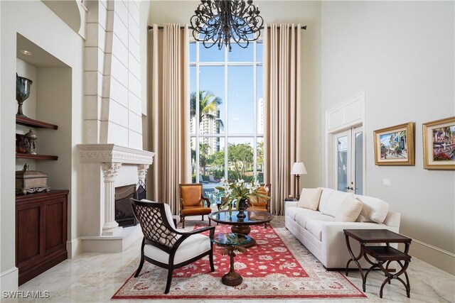 23771 Tuscany Way, Bonita Springs, FL 34134 - living area with an inviting chandelier, marble finish floor, a high ceiling, and ornate columns