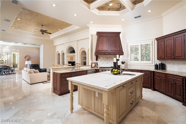 23771 Tuscany Way, Bonita Springs, FL 34134 - kitchen featuring open floor plan, custom range hood, a center island with sink, a sink, and a ceiling fan