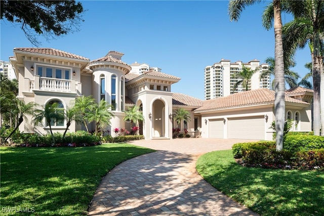 23771 Tuscany Way, Bonita Springs, FL 34134 - mediterranean / spanish-style house with a tile roof, stucco siding, an attached garage, a balcony, and decorative driveway