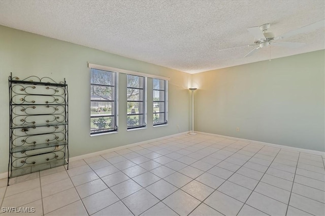 2220 SE 2nd Ter, Cape Coral, FL 33990 - empty room featuring a textured ceiling, a ceiling fan, light tile patterned floors, and baseboards