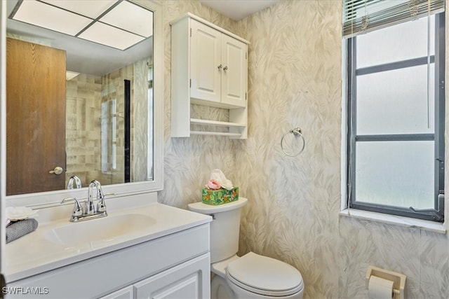 2220 SE 2nd Ter, Cape Coral, FL 33990 - bathroom with plenty of natural light, wallpapered walls, toilet, and vanity