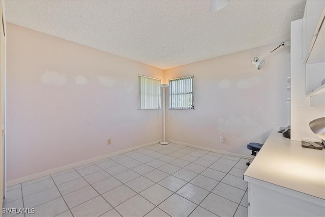 2220 SE 2nd Ter, Cape Coral, FL 33990 - interior space featuring a textured ceiling, light tile patterned flooring, and baseboards