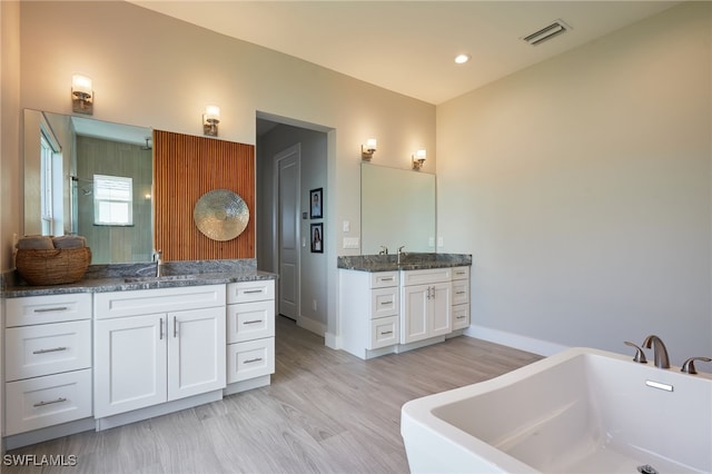 42207 Lake Timber Dr, Punta Gorda, FL 33982 - bathroom with a freestanding tub, two vanities, visible vents, and a sink