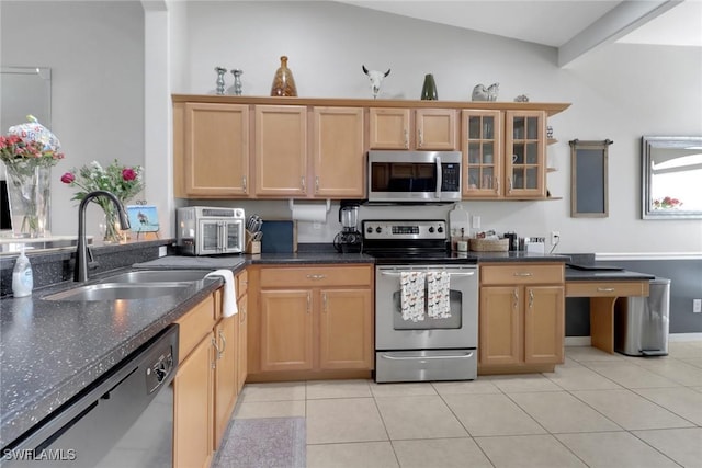 15501 Cortona Way, Naples, FL 34120 - kitchen with stainless steel appliances, a sink, light tile patterned flooring, and dark stone counters