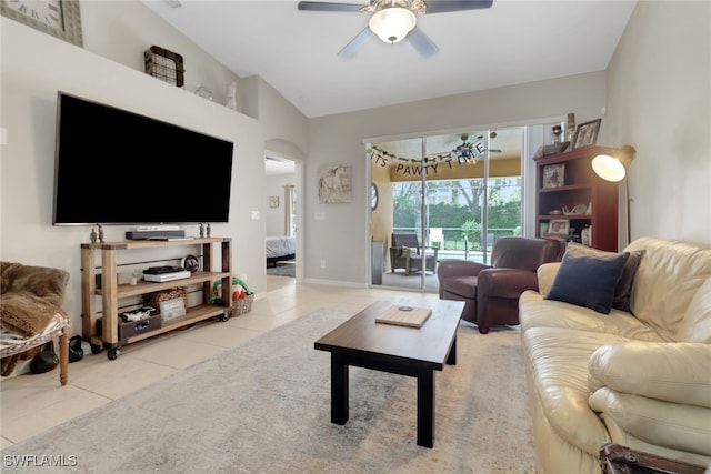 15501 Cortona Way, Naples, FL 34120 - living room with light tile patterned floors, ceiling fan, vaulted ceiling, and baseboards