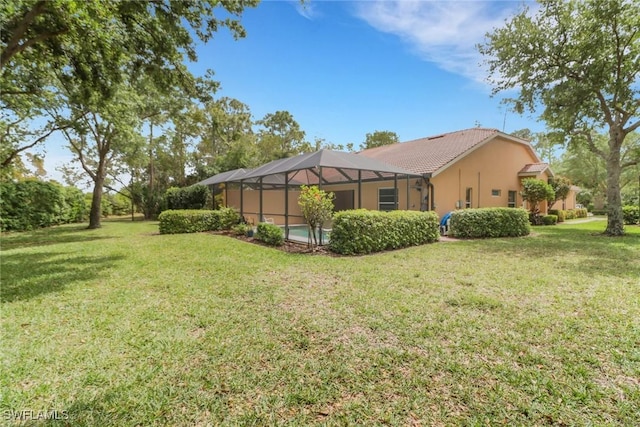 15501 Cortona Way, Naples, FL 34120 - back of house featuring a yard, glass enclosure, and stucco siding