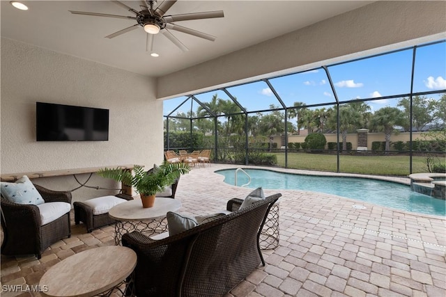 view of pool with a patio, a pool with connected hot tub, glass enclosure, and a ceiling fan