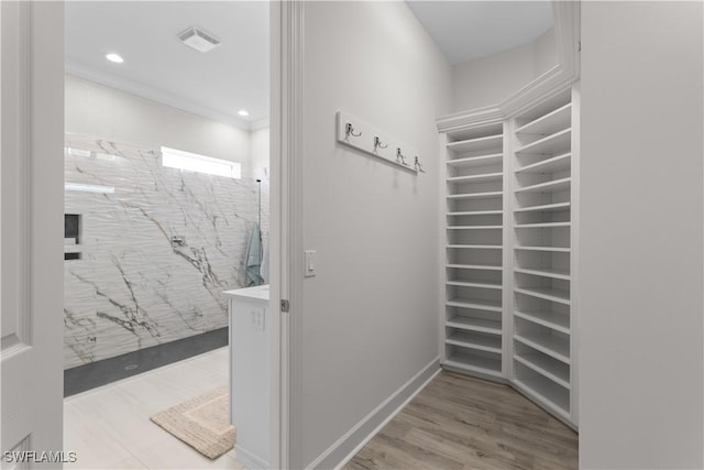 interior space featuring visible vents, ornamental molding, recessed lighting, wood finished floors, and a marble finish shower