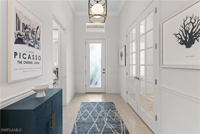 foyer with crown molding, french doors, and light tile patterned floors