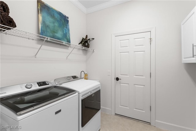 washroom featuring crown molding, independent washer and dryer, light tile patterned flooring, baseboards, and cabinet space