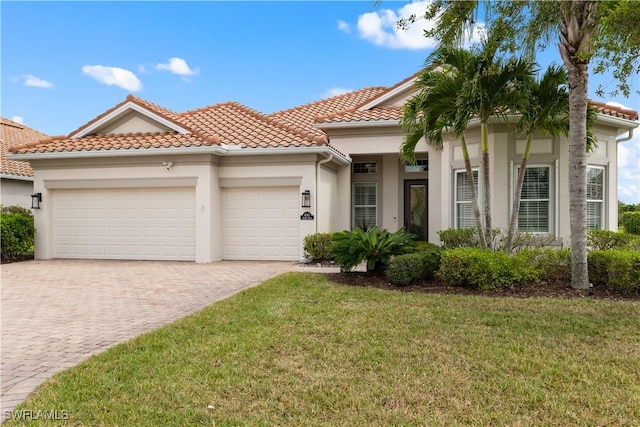 mediterranean / spanish-style house featuring stucco siding, decorative driveway, a front yard, a tile roof, and a garage