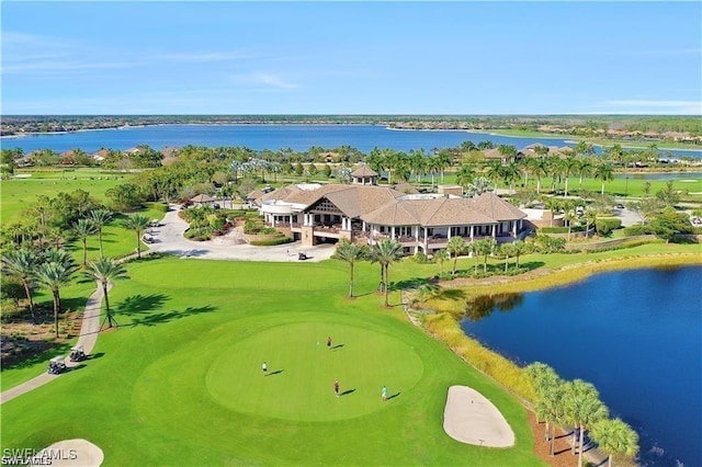 drone / aerial view featuring view of golf course and a water view