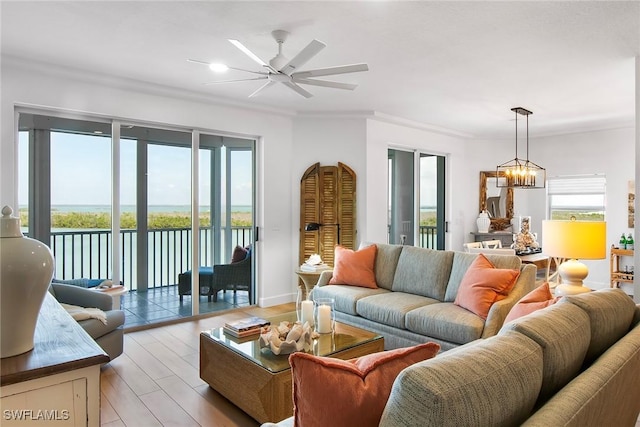 4141 Bay Beach Ln Unit 475, Fort Myers Beach, FL 33931 - living room with a water view, a wealth of natural light, light wood-style flooring, and ceiling fan with notable chandelier