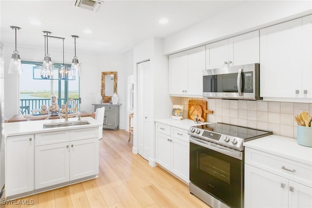 4141 Bay Beach Ln Unit 475, Fort Myers Beach, FL 33931 - kitchen with a sink, white cabinetry, visible vents, backsplash, and appliances with stainless steel finishes