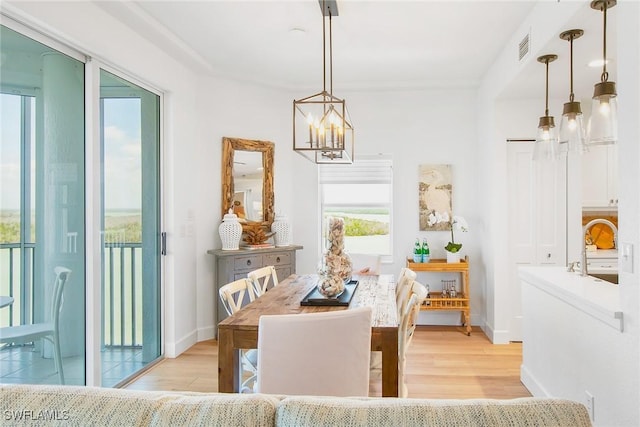 4141 Bay Beach Ln Unit 475, Fort Myers Beach, FL 33931 - dining room with baseboards, a chandelier, and light wood-type flooring