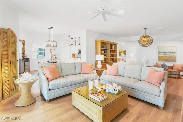 4141 Bay Beach Ln Unit 475, Fort Myers Beach, FL 33931 - living area featuring light wood finished floors and ceiling fan with notable chandelier