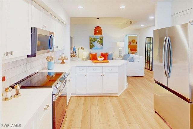 4141 Bay Beach Ln Unit 475, Fort Myers Beach, FL 33931 - kitchen featuring a peninsula, stainless steel appliances, open floor plan, and light wood-style floors