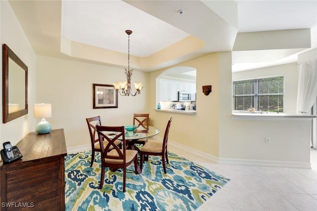 10530 Amiata Way Unit 105, Fort Myers, FL 33913 - dining room featuring light tile patterned floors, a tray ceiling, and baseboards