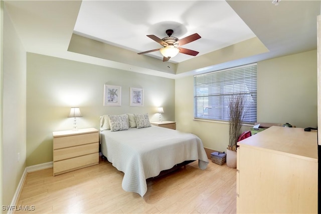10530 Amiata Way Unit 105, Fort Myers, FL 33913 - bedroom with a tray ceiling, baseboards, light wood-type flooring, and ceiling fan