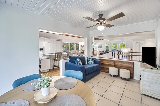living room with ceiling fan, light tile patterned flooring, and ornamental molding