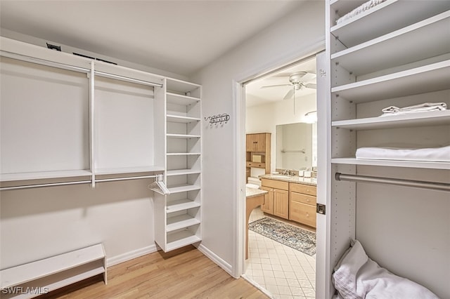 spacious closet featuring light wood-style floors and a ceiling fan