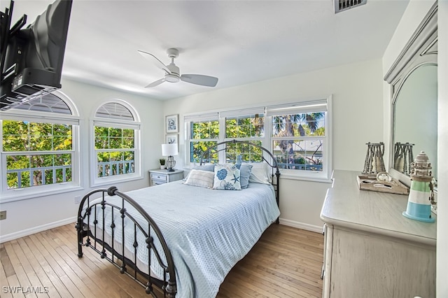bedroom featuring visible vents, multiple windows, light wood-style flooring, and baseboards