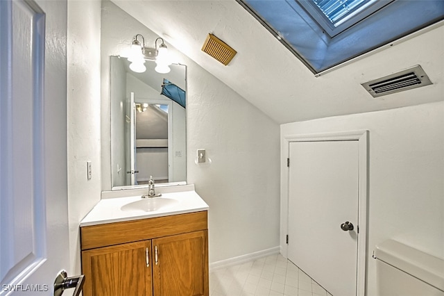 bathroom with vanity, a skylight, baseboards, and visible vents