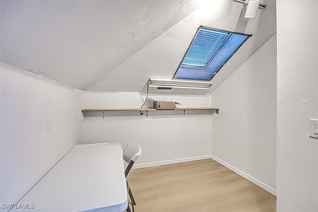 walk in closet featuring wood finished floors and vaulted ceiling