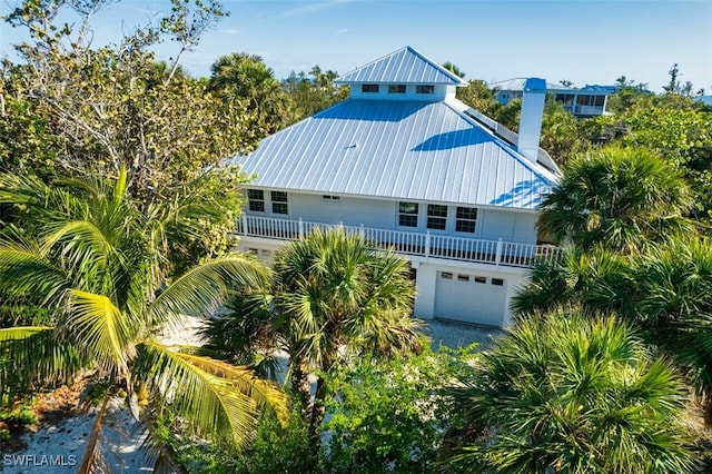 view of side of property featuring metal roof and a garage