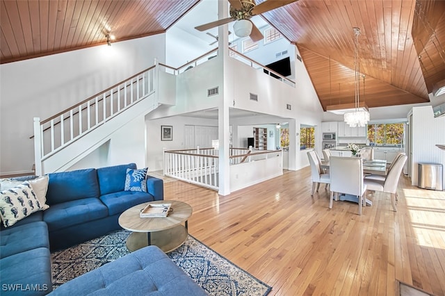 living room featuring visible vents, ceiling fan with notable chandelier, wood ceiling, and light wood finished floors
