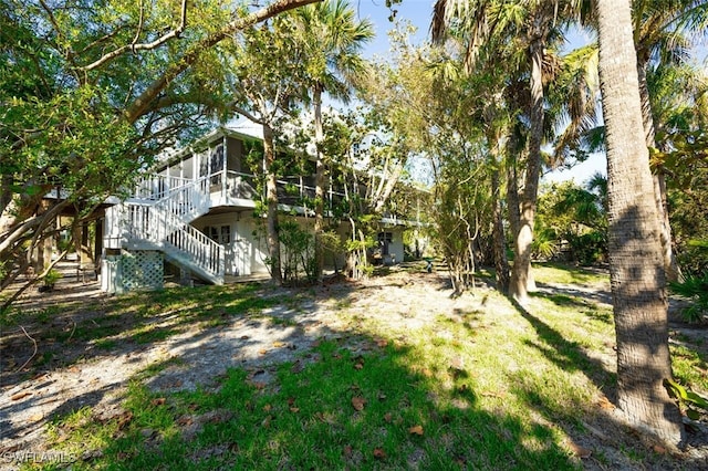 view of yard with stairway and a sunroom