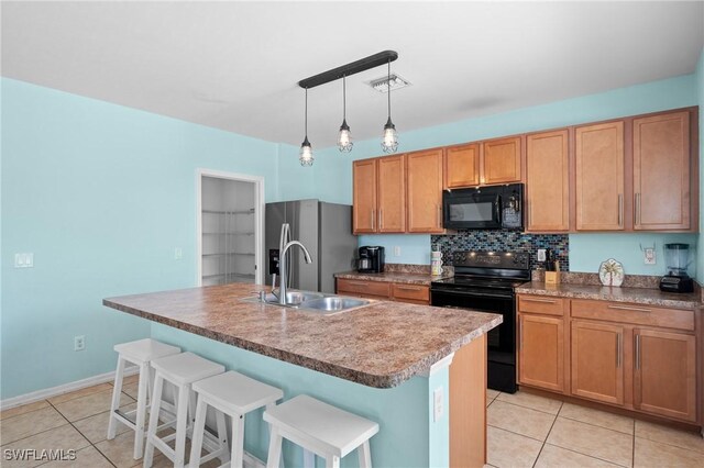 326 SW 31st St, Cape Coral, FL 33914 - kitchen with a sink, black appliances, light tile patterned flooring, and a center island with sink