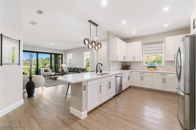 8021 Calle Canovas Ct, Naples, FL 34114 - kitchen featuring stainless steel appliances, a sink, backsplash, light wood-type flooring, and recessed lighting