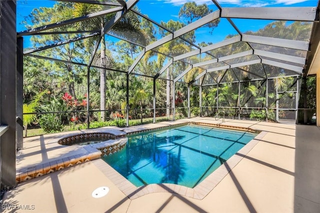 view of swimming pool featuring a pool with connected hot tub, a lanai, and a patio area