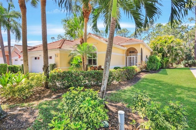 view of front of house featuring a front lawn, a tiled roof, an attached garage, and stucco siding