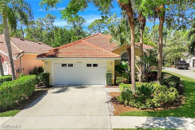 mediterranean / spanish home with a tile roof, an attached garage, concrete driveway, and stucco siding