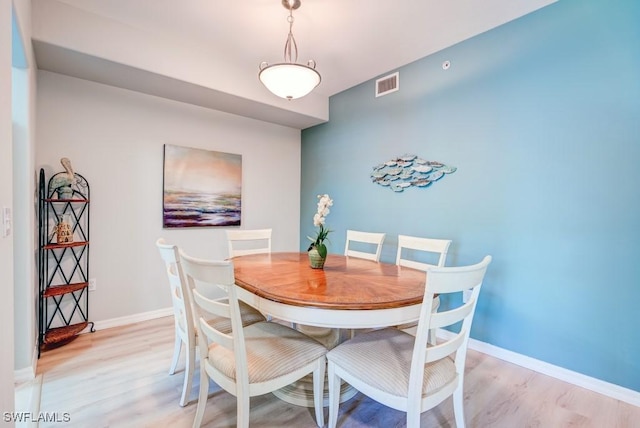 dining space with baseboards, visible vents, and light wood-style flooring