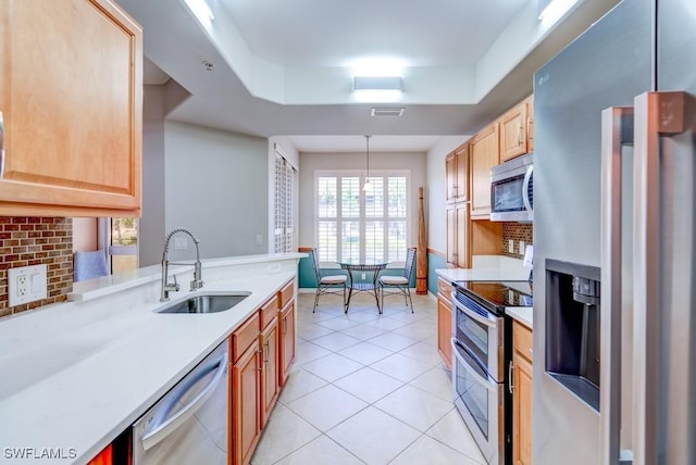 kitchen featuring a sink, light brown cabinets, stainless steel appliances, and light countertops