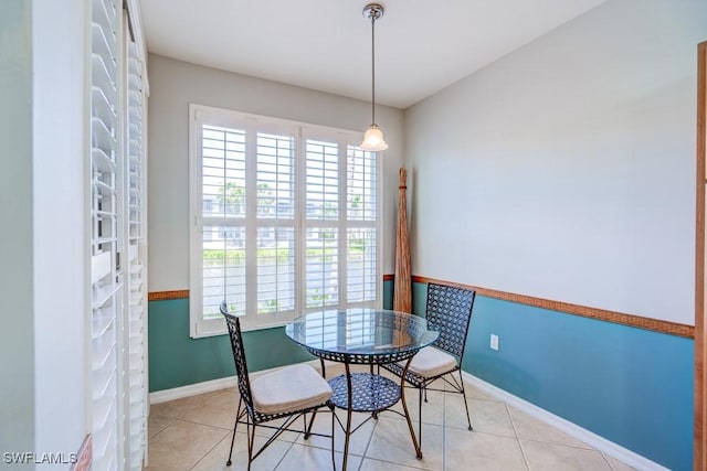 tiled dining area with baseboards and plenty of natural light