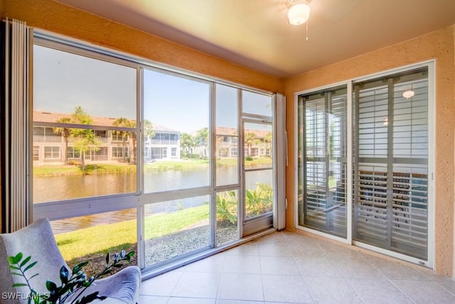 unfurnished sunroom featuring a water view and tile patterned floors